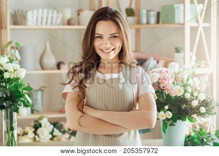 Young female florist working with flowers smiling