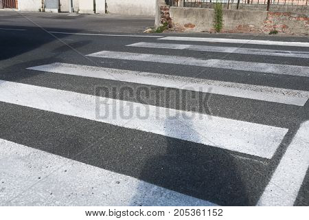 A pedestrian crossroad with human shadow ready to cross