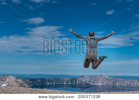 Man Leaps at Overlook to Crater Lake on Calm Morning