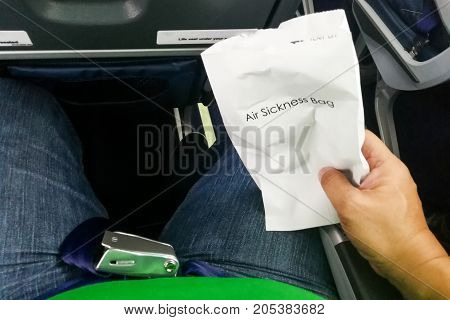 Airsick Nauseous Person Holding The Air Sickness Vomit Bag