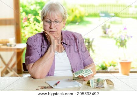 worried female senior is calculating her budget