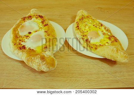 Adjarian khachapuri with eggs on the table. Delicious homemade khachapuri in Adjarian - Retro color