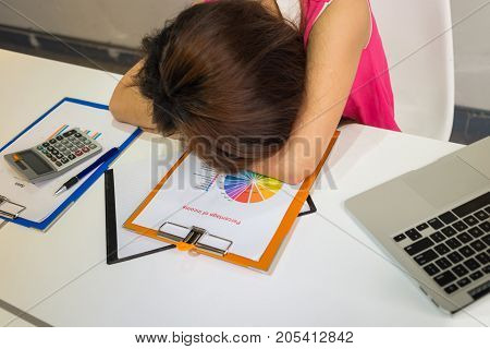 Tired employee sleeping in office after working a long day