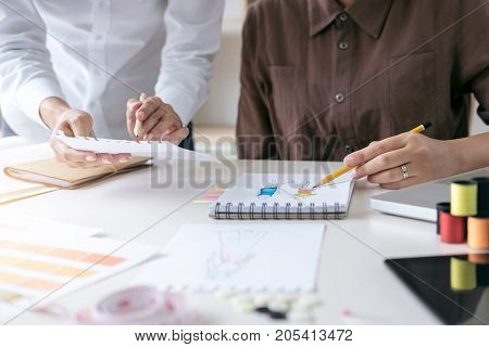 Two professional stylish fashion designer working as fashion designers measure as sketches in workshop of new collection in art Creative Design and Artistic Concept.