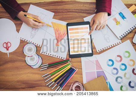 Young woman designer working as fashion designers at work with fashion sketches and color charts profession and job occupation Fashion Designer Stylish Concept.