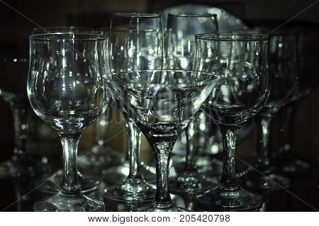 Crystal wine glasses in a dark cupboard.