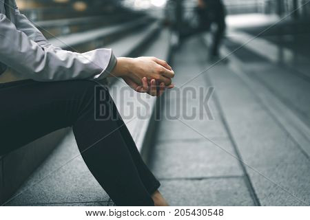 Close-up hands of businesswoman stressed from work while sitting outdoors on the stairs concept work life balance burn out syndrome press from colleagues.