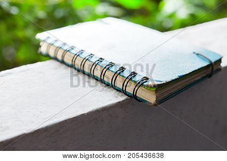 Old diary for memory place on wall with green backgroundBlue note book