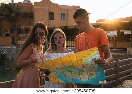 tourists with map reserch the city on sunset.