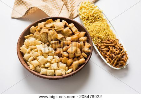 stock photo of Yellow Namkeen sev variety with shakkar para or shankar pale, Shakkarpare, Shakarpali served in white bowls arranged artistically, selective focus