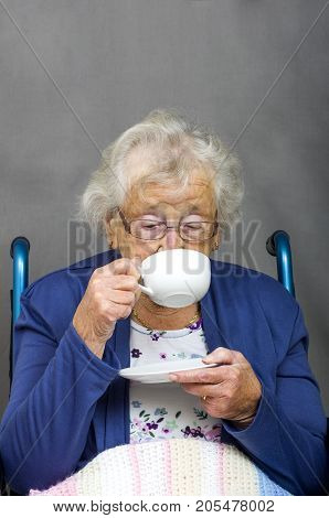 Senior Citizen Drinking
Senior citizen in a wheel chair drinking from a cup and saucer.