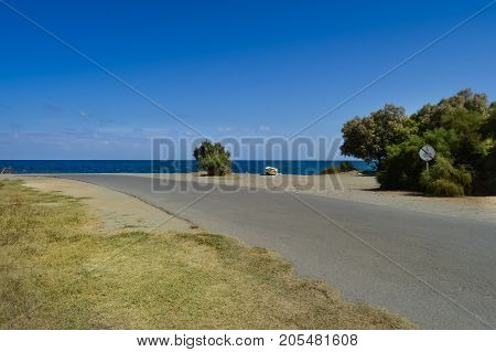 Road to the pebble beach of Maleme with a boat abandon in the north west of the island of Crete in Greece