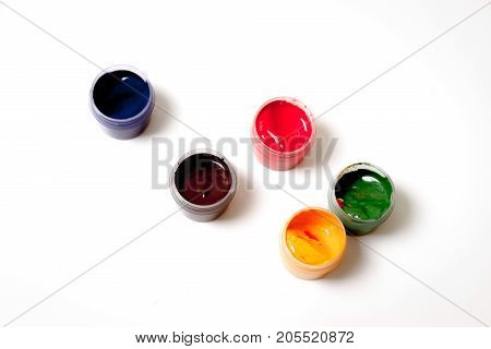 Color gouache jars on white background. Top view, copy space