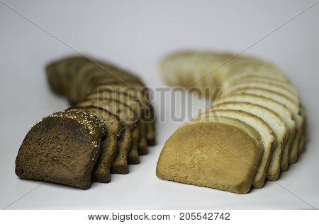 Pieces of black and white bread spread out on a white background