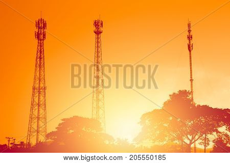 Silhouette Multiple Band Telephone Cellsite Towers Antenna On Sunset Dusk Orange Sky