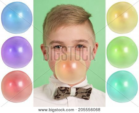 Boy blowing a bubblegum bubble isolated on green. Plus six blanks