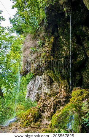 Photo of little beautiful waterfall flowing in cave