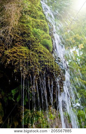 Photo of little beautiful waterfall flowing in cave