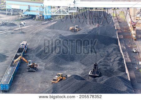 Work in port coal transshipment terminal. Coal unloading of wagons with special cranes. Working in a port near the Baltic Sea