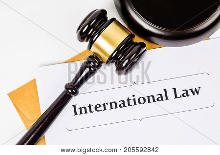 International law documet and wooden judge on white background.