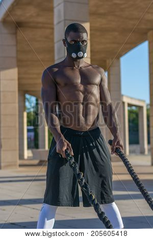 Male Muscular Training With Battle Ropes And Training Mask