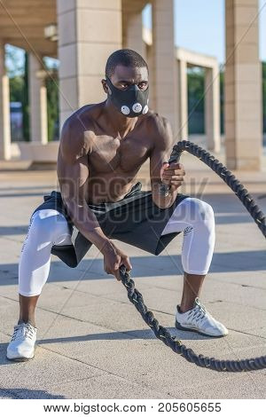 Male Muscular Training With Battle Ropes And Training Mask