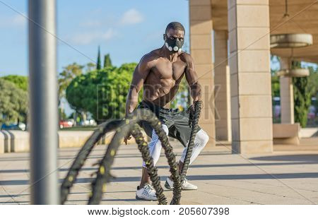 Male Muscular Training With Battle Ropes And Training Mask