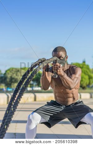 Male Muscular Training With Battle Ropes And Training Mask