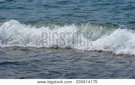 closeup view of small waves on the sea coast sea water has a turquoise color the foam of the sea waves