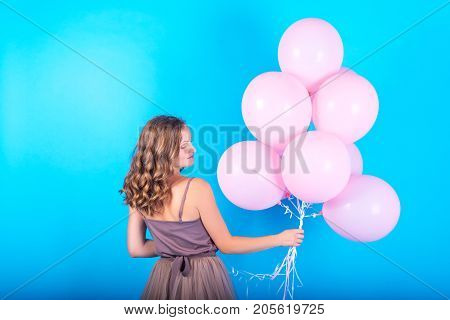 Beautiful Young Woman Having Fun With Pink Helium Air Balloons On Blue Background. Girl With Curly H