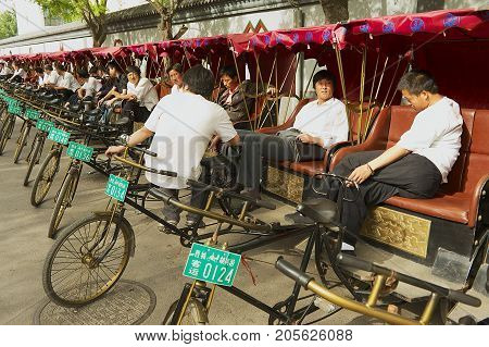 BEIJING, CHINA - MAY 01, 2013: Unidentified rickshaws wait for passengers at Futong street next to the Houhai lake in Beijing, China.