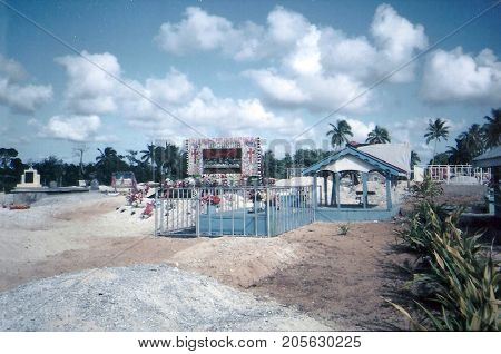 NUKU'ALOFA / TONGA - CIRCA 1990: Graves in a cemetery in Nuku'alofa, on the island of Tongatapu, are decorated with tapestries and other items.