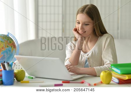 Portrait of cute teen girl using modern laptop