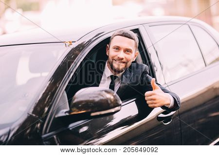 Handsome Young Beatded Businessman In A Car With Thumbs Up