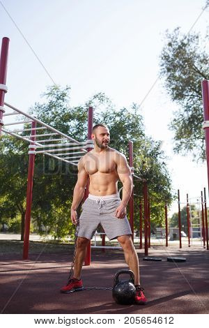 Full length of sporty and healthy muscular man exercising outdoors. Sexy young man with a muscular body on a natural background. Strong and perfect male body.