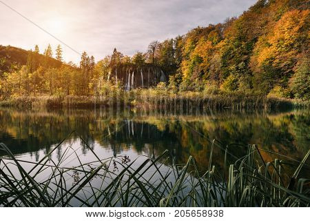 Croatia. Plitvice Lakes at the Galovac Waterfall in Autumn Majestic view on waterfall with turquoise water and sunny beams in the Plitvice Lakes National Park. Forest glowing by sunlight. Croatia. Europe. Dramatic morning scene. Beauty world.