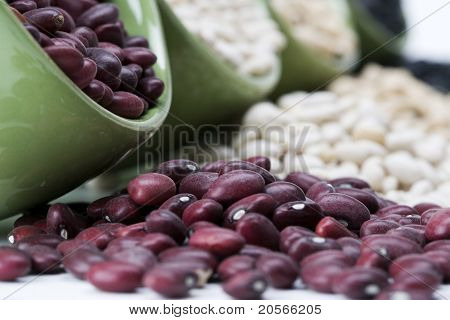 Surtidos frijoles mixtos se derrame de un plato de cerámico verde