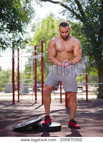 Full length of sporty and healthy muscular man exercising outdoors. Sexy young man with a muscular body on a natural background. Strong and perfect male body.
