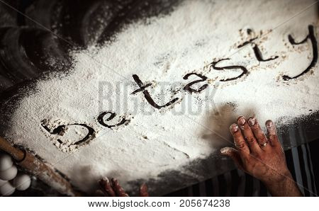 Man makes dough from flour and eggs on a glass table