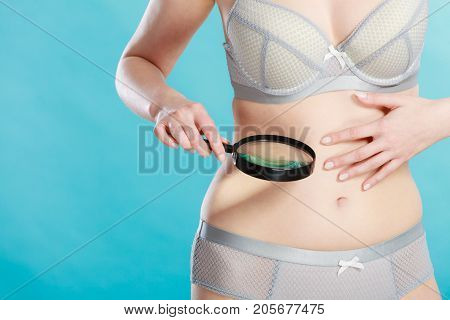 Woman Using Magnifying Glass To Examine Her Moles Skin