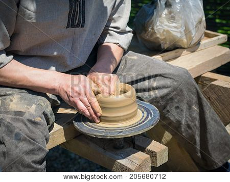 Mens hand made pottery clay old-fashioned way. The concept of the production of pottery in the past.