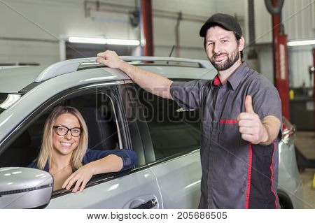 An auto mechanic and female customer in garage