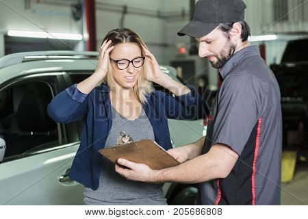An auto mechanic and female customer in garage