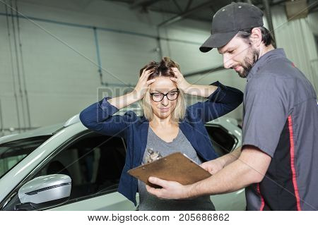 An auto mechanic and female customer in garage