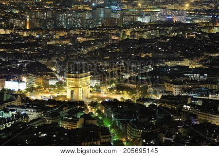 Aerial Night view of Arc de Triomphe and Paris City shot on the top of Eiffel Tower
