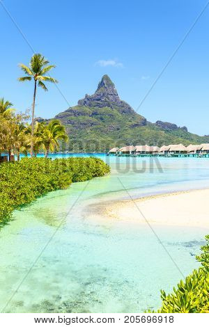 View on Mount Otemanu through turquoise lagoon and overwater bungalows on the tropical island Bora Bora Tahiti French Polynesia Pacific ocean.