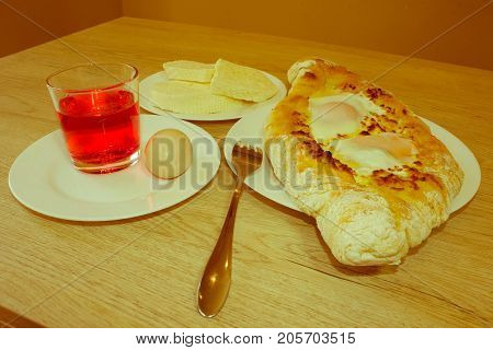 Adjarian khachapuri close-up. This traditional georgian dish contains brinsen cheese butter and row egg. Delicious homemade khachapuri in Adjarian - Retro color