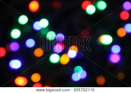 Bokeh of multicolored highlights on a black background. holiday atmosphere.