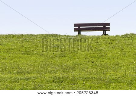 coastal scenery with wooden bench on a dam around Buesum in Dithmarschen at Schleswig-Holstein Germany