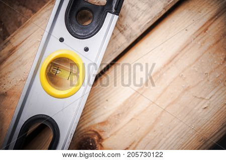 Spirit Level Tool or Bubble Level Instrument on Wooden Construction Materials Closeup Photo